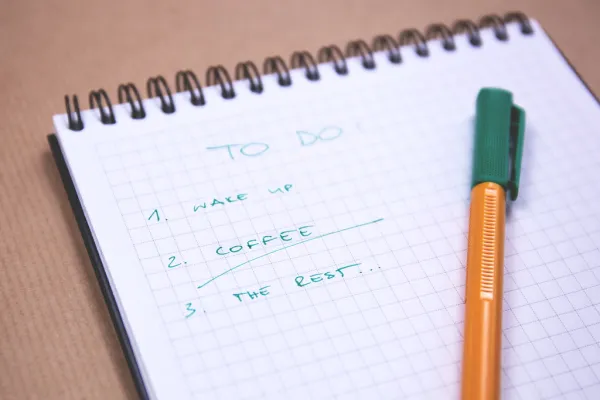 Lista de tarefas em caderno sobre a mesa de trabalho